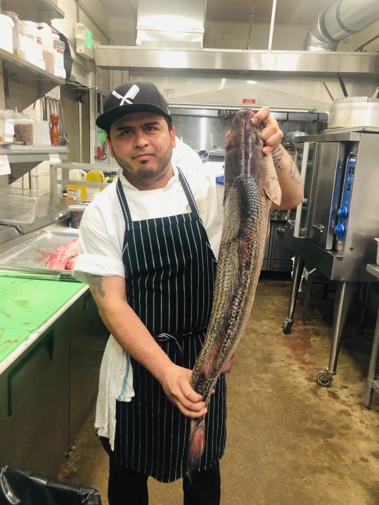 Chef Lupe with the day’s fish in the kitchen