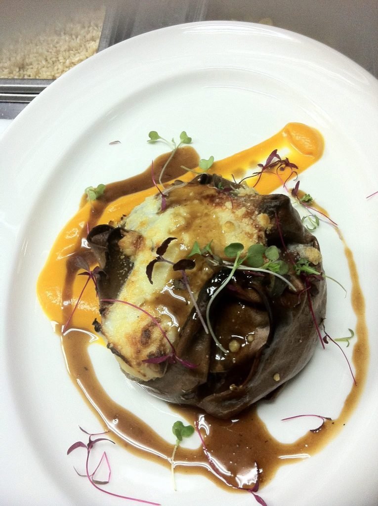 A slow-cooked beef course under shaved vegetables