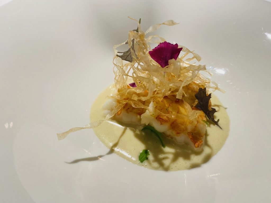 A crisp nest over cured fish, finished with a rose petal