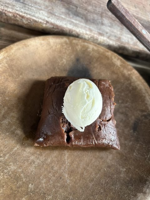 A chocolate dessert under a quenelle of cream