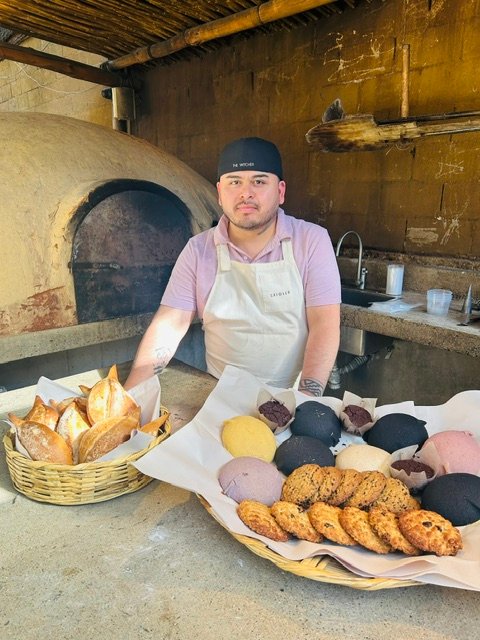 Chef Lupe at the wood-fired oven with the morning&rsquo;s baking