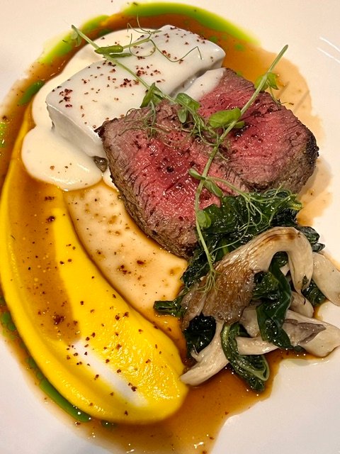 A beef course with mushrooms, greens and two purées