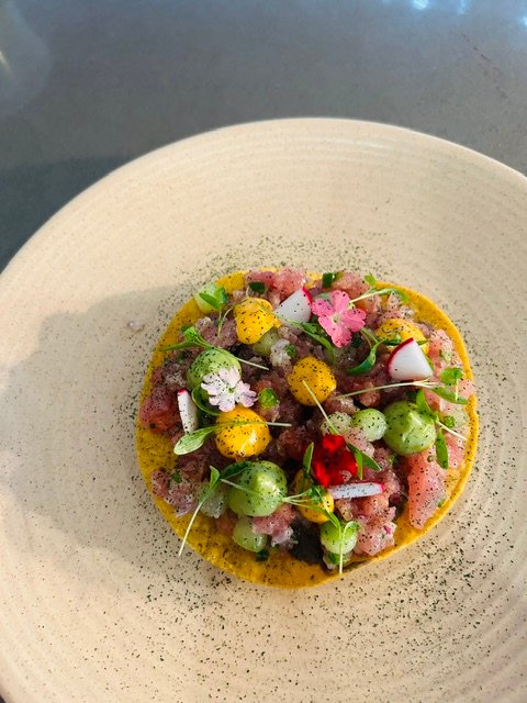 Tartare on a tostada, dressed with flowers and herbs