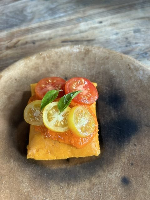 Sliced tomatoes and basil on a rustic plate