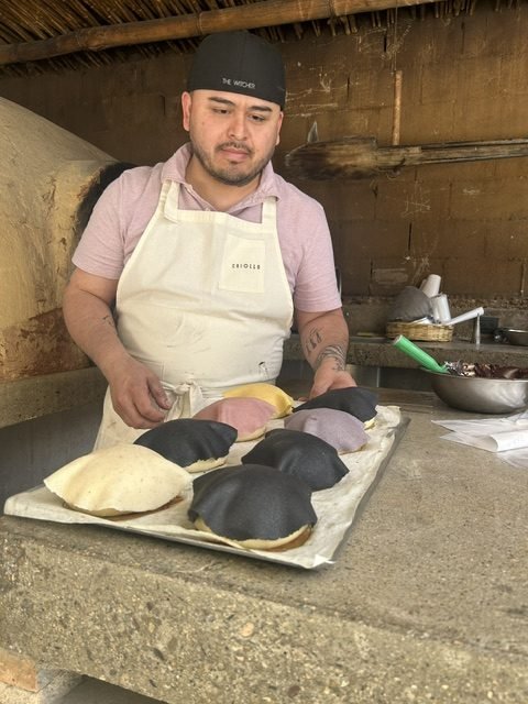 Chef Lupe cooking tortillas beside a wood-fired oven